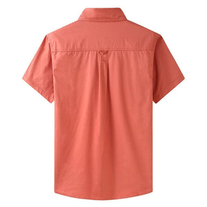 Back profile of orange button-up work shirt. Short sleeve. Off-road text above left chest.