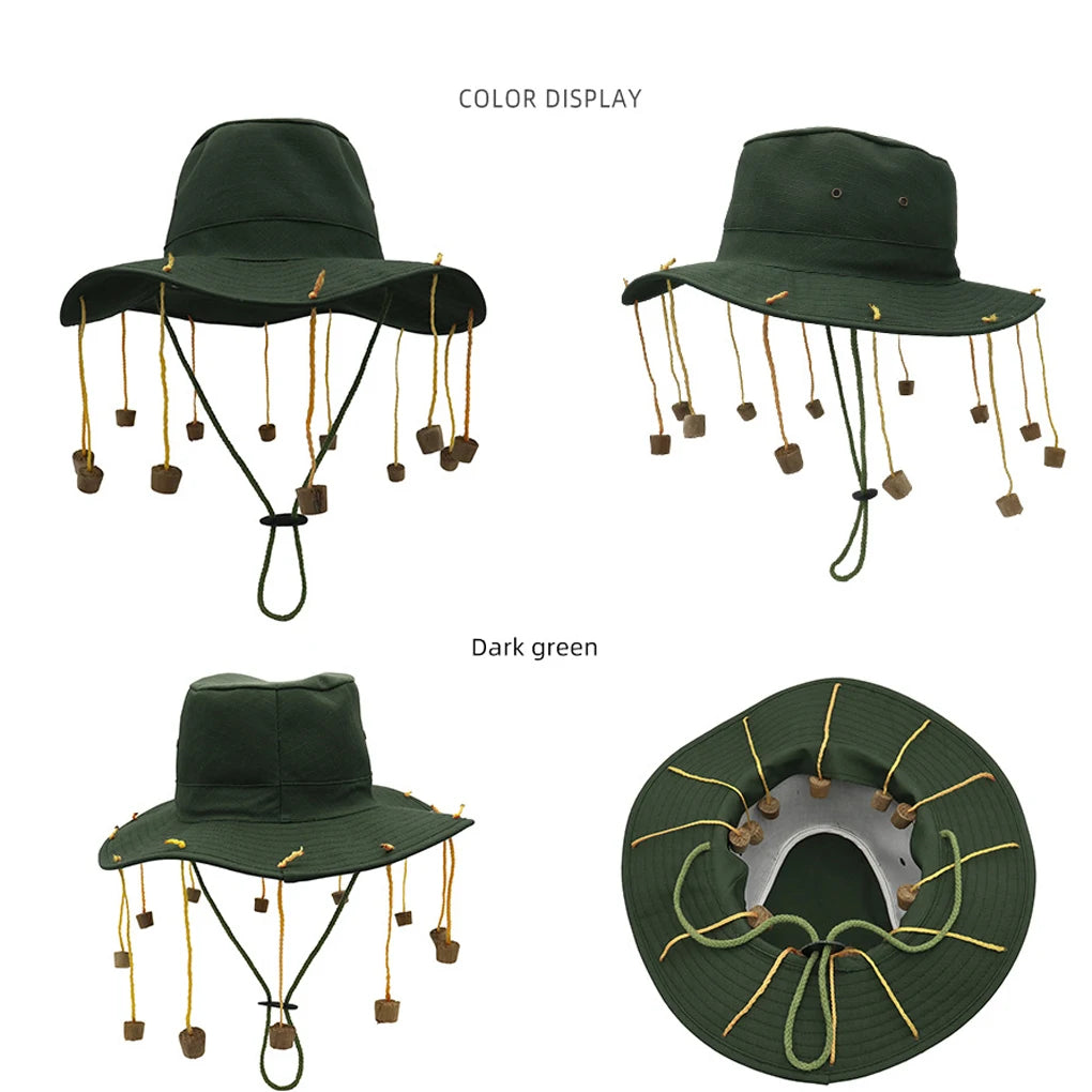 Dark green bucket cap with cork end tassels hanging down from the brim on a white background. 