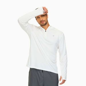 Male model wearing a white long sleeve sun protection shirt and grey sports pants. He is wiping the sweat from his forehead. 