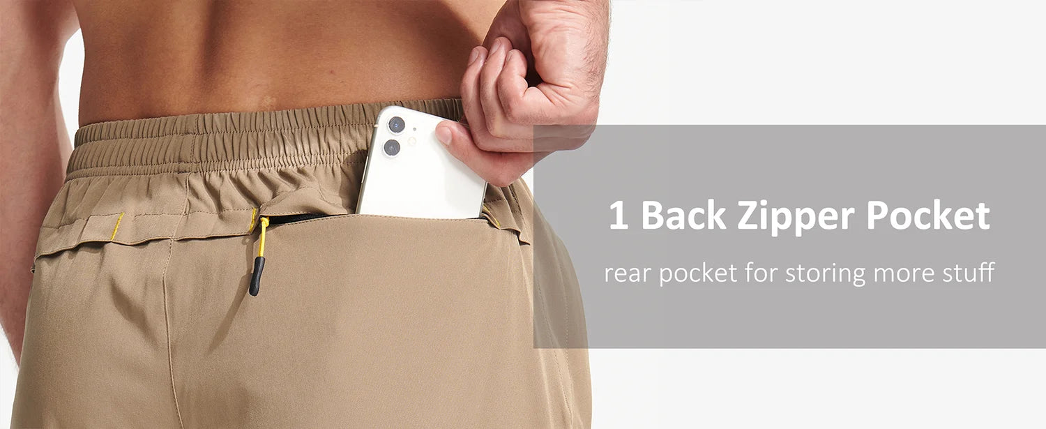 Person wearing beige shorts with a back zipper pocket, holding a phone.