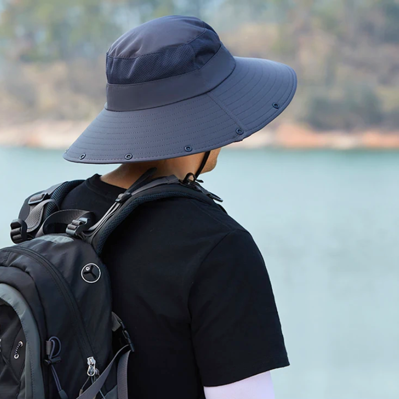 Man wearing the Detachable Flap Fishing Hat looking at a lake.