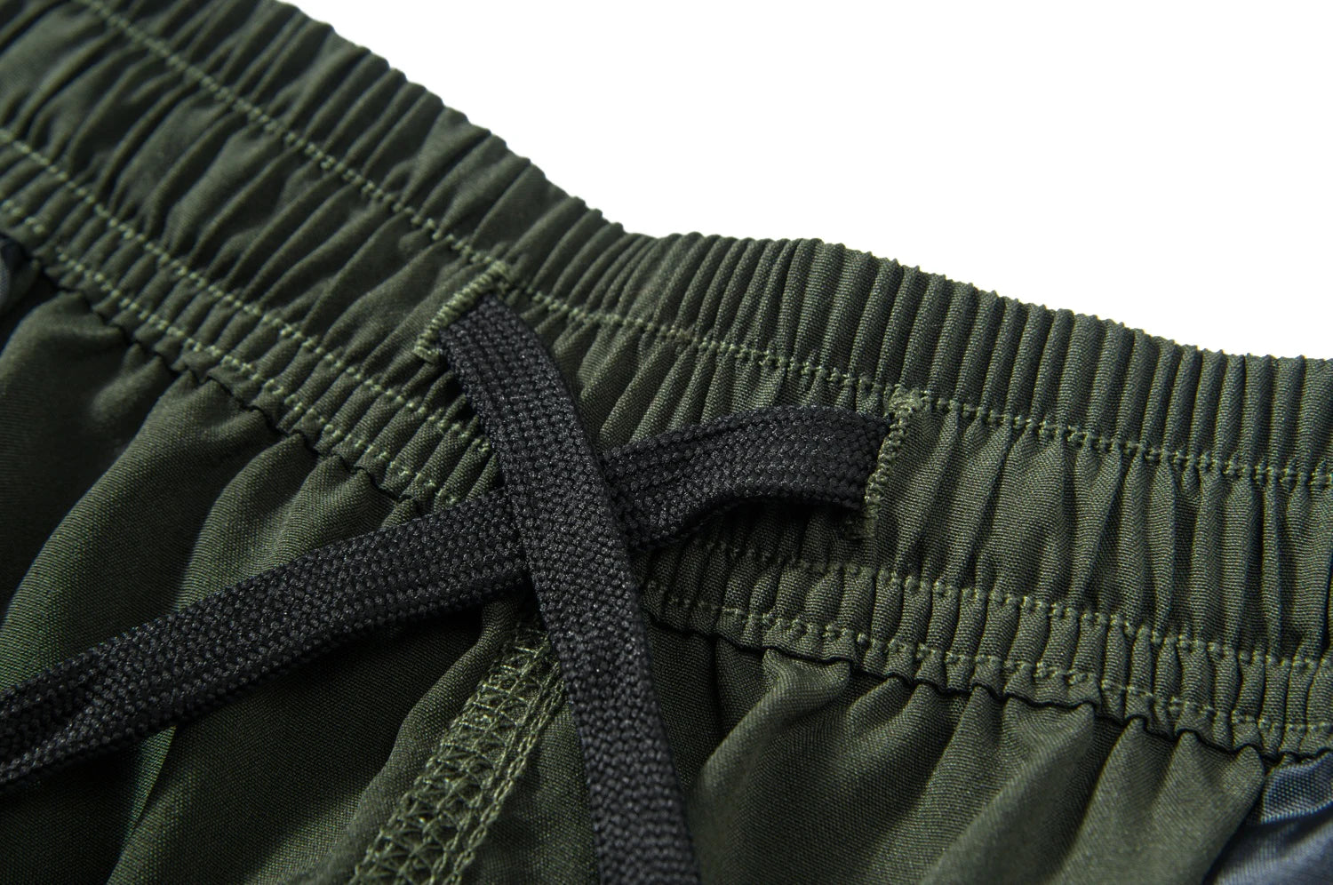 Close-up of green shorts with an internal drawstring on a white background.