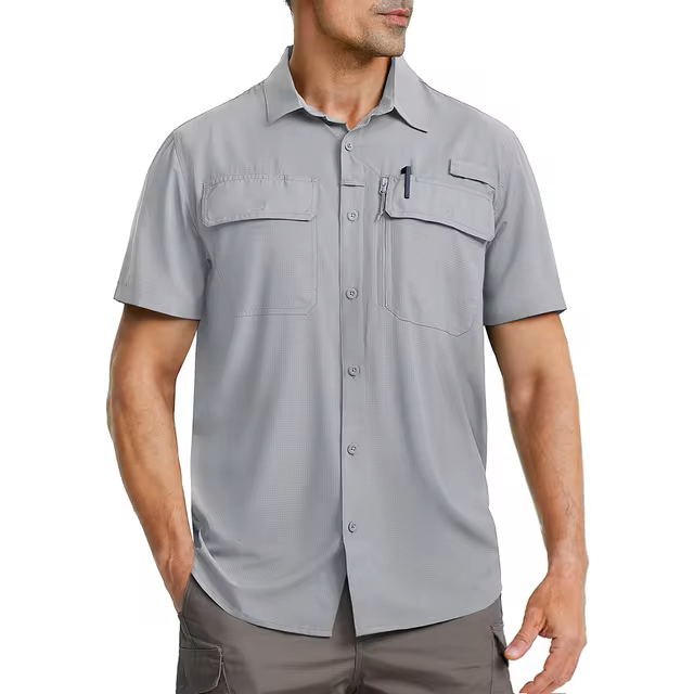 Male model wearing a light grey short sleeve shirt that has many pockets.