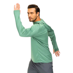 Male model swinging his arms while wearing a green UPF 50+ sun protection shirt and grey sports pants.