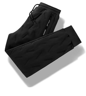 A thick warm pair of black drawstring pants folded on a table. 