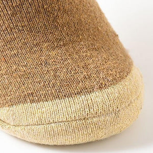 The toe part of a thick pair of brown and cream socks made from camel hair.