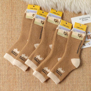 Camel hair socks on display laying on a brown rug.