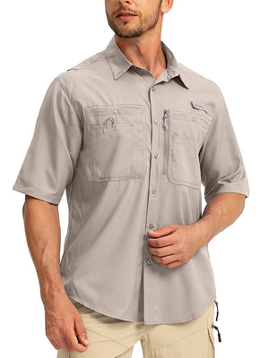 Man wearing a Gradual brand short sleeve button-up khaki fishing shirt. The shirt has multipole pockets including a zip pocket.