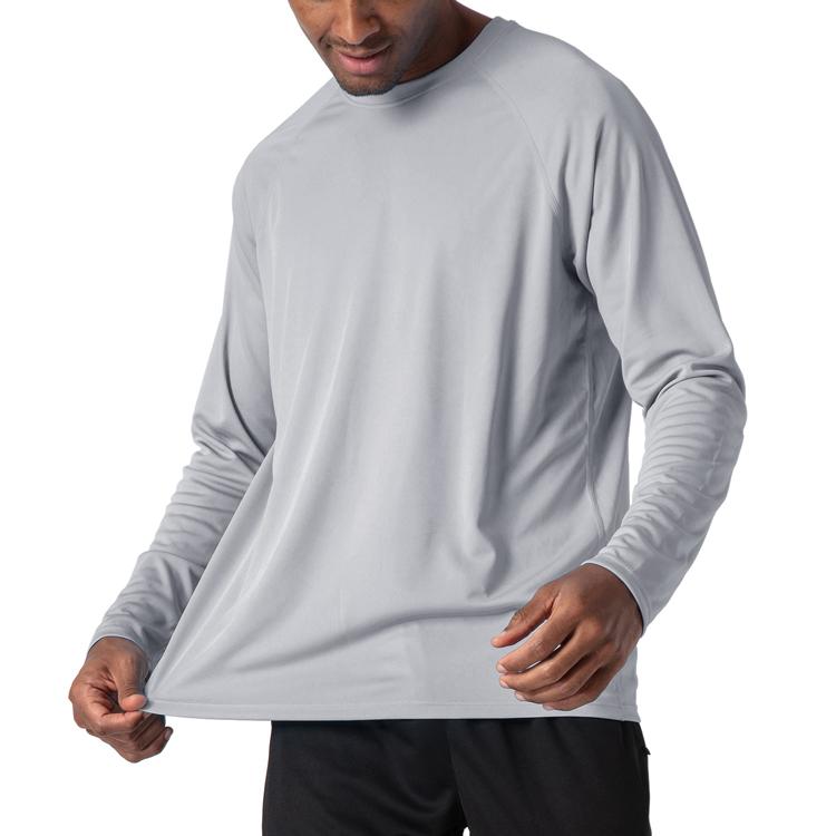 Male model wearing a light grey, long sleeve t-shirt for sun protection.