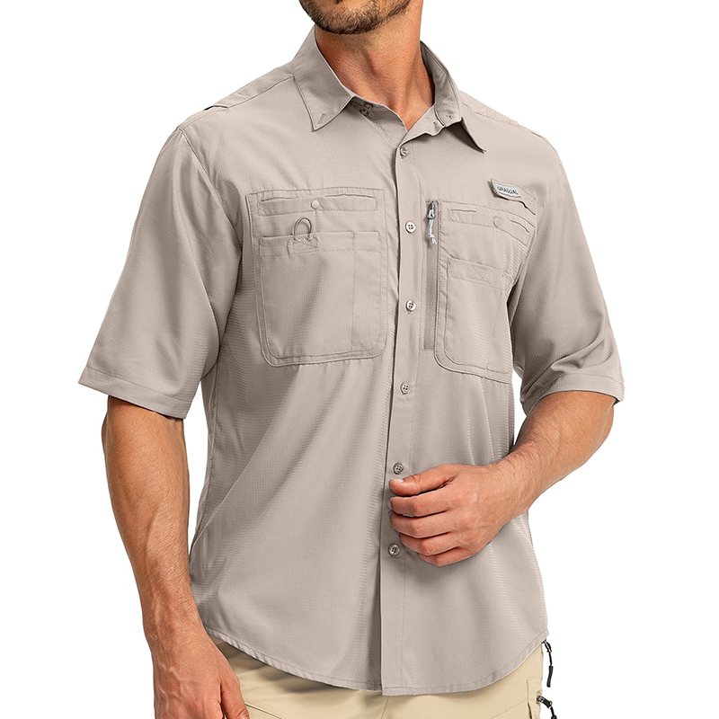 Man wearing a short sleeve khaki fishing shirt. The shirt has multipole pockets including a zip pocket.