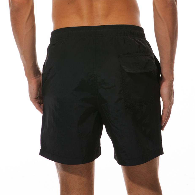 Back pocket on a pair of men's black swim shorts.