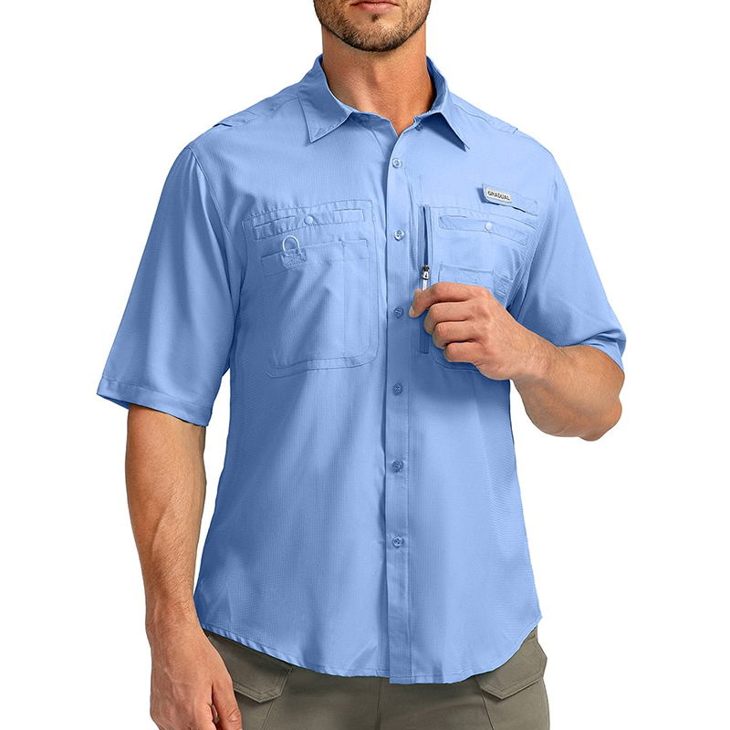 Man wearing a light blue short sleeve button-up fishing shirt. The shirt has multiple chest pockets, one with a zip.
