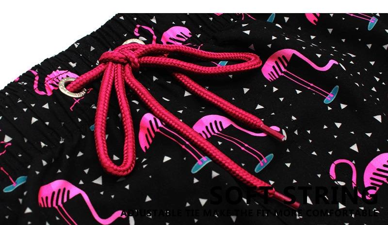 Showcasing the coloured drawstring on a pair of flamingo print shorts.