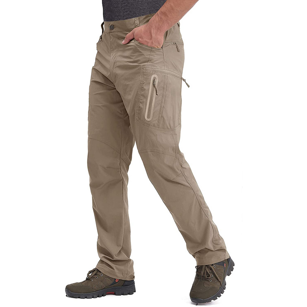 Man wearing khaki hiking pants with multiple zip pockets. The pants are made from lightweight Nylon and Spandex cloth.