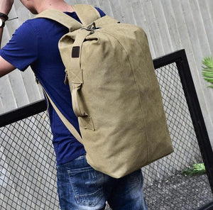 Male model standing wearing the canvas rucksack. 