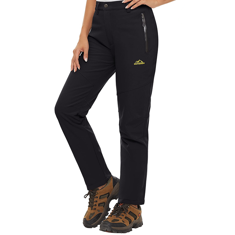 A women wearing a pair of black pants and hiking shoes. The pants are waterproof and have a warm fleece lining. 