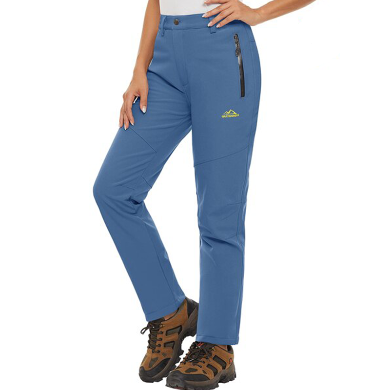 Female model wearing a pair of light blue warm winter pants. The pants have zip pockets and a fleece lining. 