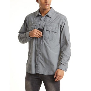 Male model wearing a grey long sleeve shirt with zip pockets and button pockets on the chest..